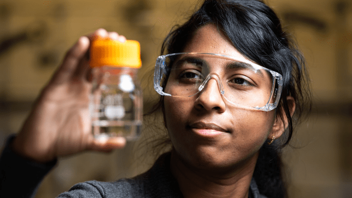 PNNL chemist Jotheeswari Kothandaraman examines a vial of methanol. Credit: Pacific Northwest National Labs.