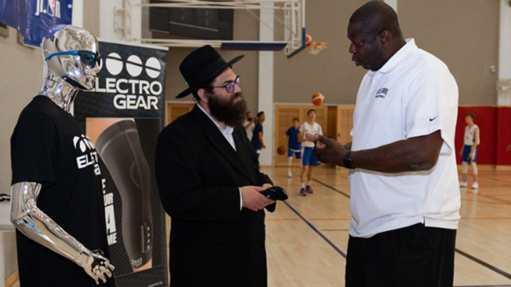 Healables CEO Moshe Lebowitz speaking to former NBA coach and player Ed Pinckney. Healables app was designed to integrate smart textiles, electronics and software to reduce inflammation, accelerate healing and relieve pain, while eliminating travel time for physical therapy. (Courtesy of Healables)